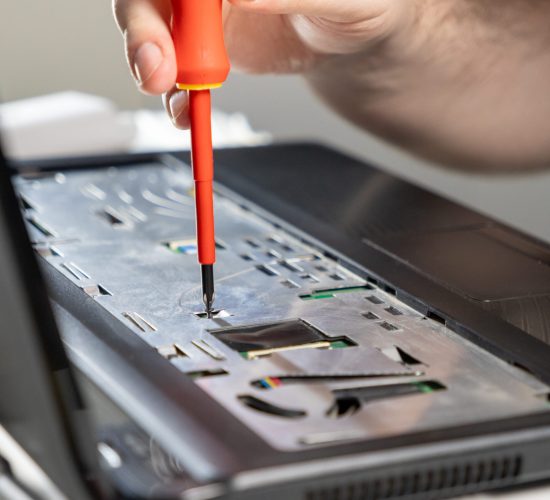 hand-using-screwdriver-adjust-component-inside-laptop-repair-focusing-keyboard-panel-area Reparación portatil Torrent